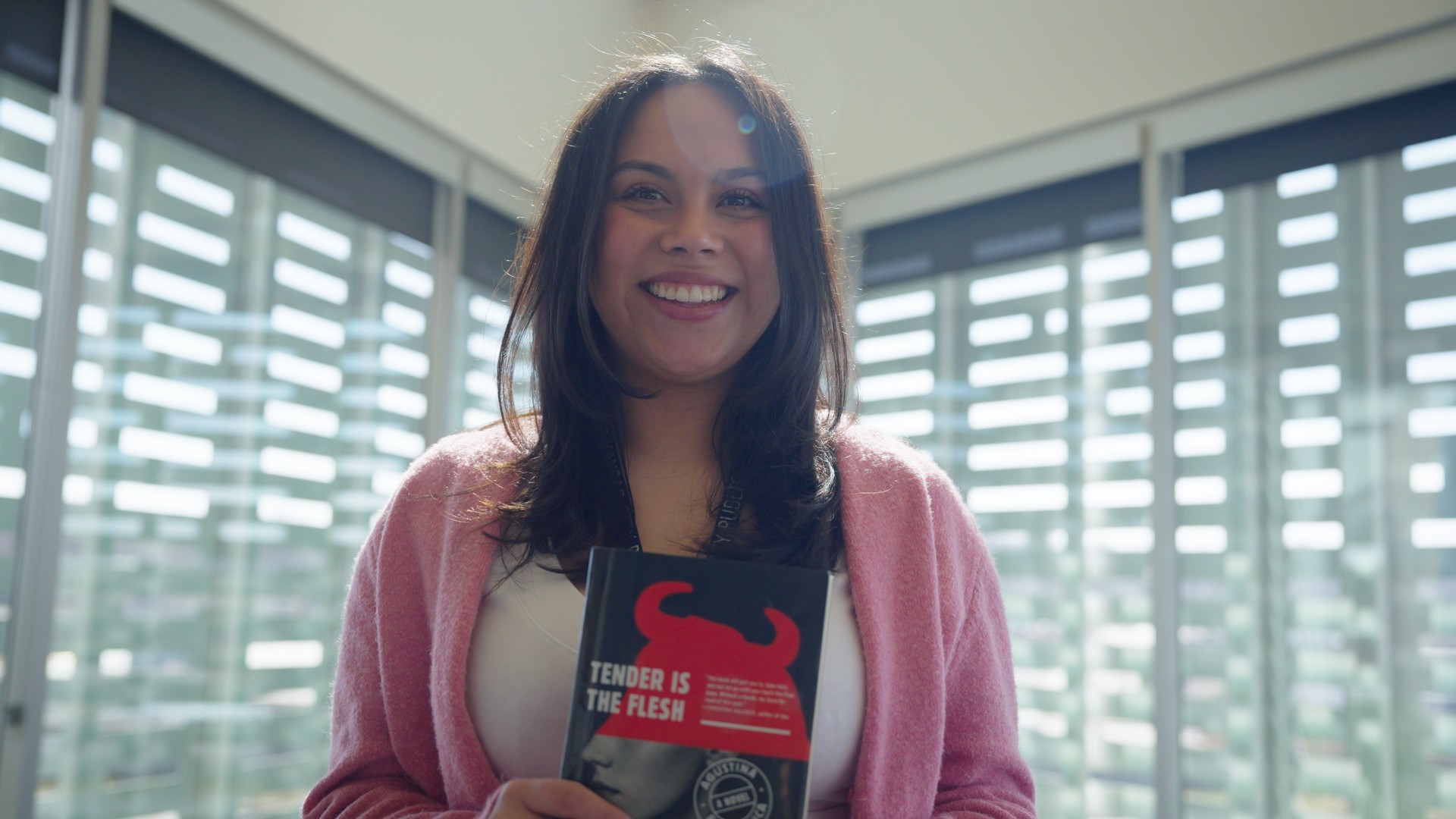 woman smiling while holding picture book